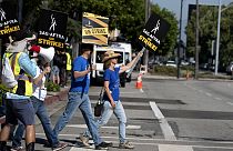 Screenwriters Meagan Daine, right, and Craig Stiles join in support SAG-AFTRA picketers outside the gates of Warner Bros. studios in California, Tuesday, Sep. 26, 2023