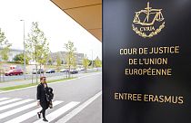 Imagen de una mujer en un paso de peatones, ante el Tribunal de Justicia de la Unión Europea, cuya sede se encuentra en Luxemburgo.