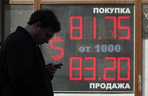 FILE - A man stands next to an exchange office screen showing the currency exchange rates of U.S. Dollar to Russian Rubles in St. Petersburg, Russia, Friday, April 7, 2023. 