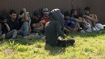 Közel-keleti illegális bevándorlók rendőri őrizet alatt a szlovákiai Ipolynagyfaluban