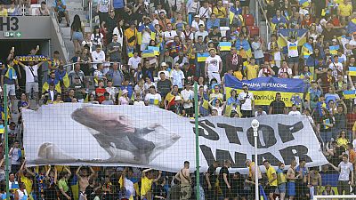Aficionados de Ucrania con un cartel de "parar la guerra"
