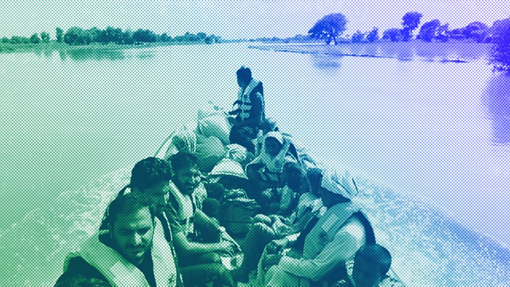 Спасители използват лодка, за да евакуират селяни от наводнена зона