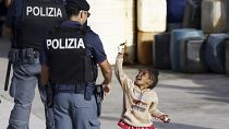 Un agente de policía observa a un niño migrante en el puerto de la isla siciliana de Lampedusa, el 18 de septiembre de 2023. 
