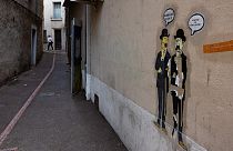 Autocolantes que mostram duas personagens de "As Aventuras de Tintim", Dupont et Dupond, numa rua de França