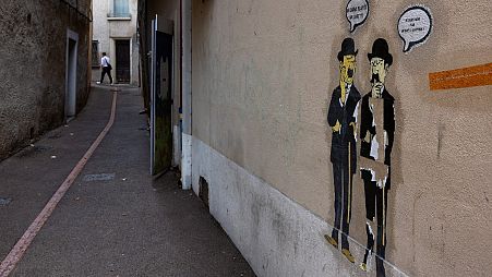 Autocolantes que mostram duas personagens de "As Aventuras de Tintim", Dupont et Dupond, numa rua de França