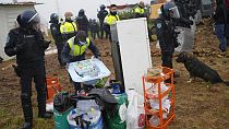 A municipal worker piles the belongings of a woman living with three small children in a makeshift house, before it was demolished, in Loures, outside Lisbon, Monday, March 6,