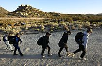 Requerentes de asilo dirigem-se à guarda fronteiriça norte-americana após terem passado fronteira com o México