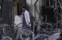 A health worker collects the remains of victims at the site of a fatal fire, in the district of Hamdaniya, Nineveh province, Iraq, Thursday, Sept. 28, 2023. 