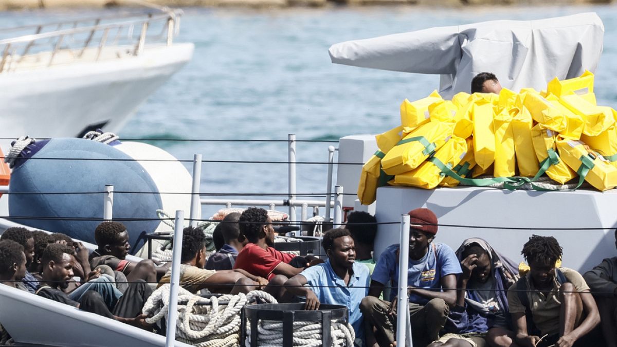 مهاجرون تم إنقاذهم يجلسون في قارب تابع للشرطة المالية الإيطالية قبل النزول في ميناء جزيرة لامبيدوسا، إيطاليا، الاثنين 18 سبتمبر 2023.
