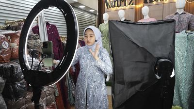 A woman conducts live sales via streaming at a store in the Tanah Abang textile market in Jakarta, Indonesia on September 28, 2023.