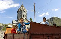Ethnic Armenian children from Nagorno-Karabakh look from a truck after arriving in Armenia's Goris in Syunik region, Armenia, on Thursday, Sept. 28, 2023.