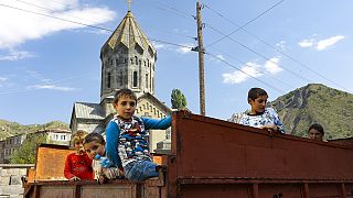 Ethnic Armenian children from Nagorno-Karabakh look from a truck after arriving in Armenia's Goris in Syunik region, Armenia, on Thursday, Sept. 28, 2023.