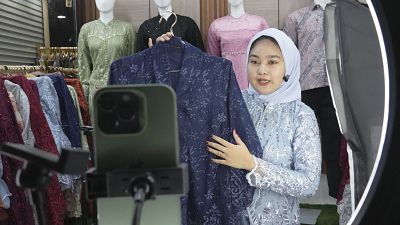 بائعة ألبسة في سوق تاناه أبانغ بجاكرتا تروج لبضاعتها من خلال فيديوهات تبثها على مواقع التواصل الاجتماعي 