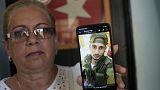 Marilin Vinent sostiene una foto de su hijo Dannys Castillo vestido con uniforme militar en su casa en La Habana, Cuba, el viernes 8 de septiembre de 2023.