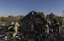 Tűzoltók eltakarítják a romokat egy orosz rakétatámadás után a donyecki Kosztjantyinivkában