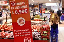 Fruits and vegetables next to a sign reading "10 fruits and vegetables with a price of 0.99 euro, anti-inflation challenge", at a Carrefour hypermarket in Paris, F