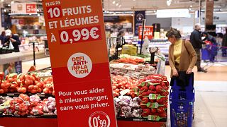 Fruits and vegetables next to a sign reading "10 fruits and vegetables with a price of 0.99 euro, anti-inflation challenge", at a Carrefour hypermarket in Paris, F