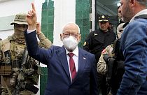  زعيم حزب النهضة  راشد الغنوشي، في الوسط، يرفع علامة النصر عند وصوله للاستجواب في مقر الشرطة القضائية في تونس، 1 أبريل، 2022.