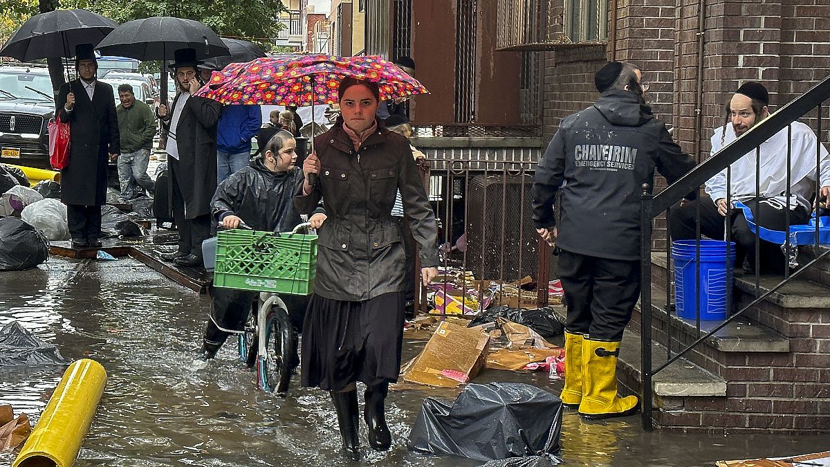 مشاة في أحد الشوارع التي غمرتها مياه الأمطار في حي بروكلين بمدينة نيويورك الأمريكية