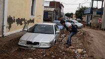 Residente de Agria, na Grécia, tenta libertar o carro da lama