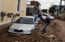 Residente de Agria, na Grécia, tenta libertar o carro da lama
