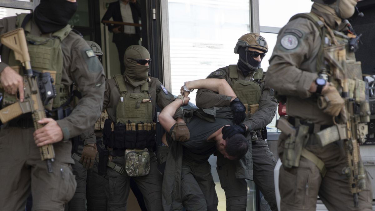 Policías kosovares sacan del tribunal en Prístina, la capital kosovar, a uno de los serbios implicados en el tiroteo