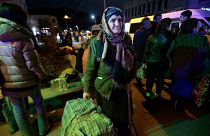 An ethnic Armenian woman from Nagorno-Karabakh carries her suitcase to a tent camp after arriving to Armenia's Goris in Syunik region, Armenia, late on Friday