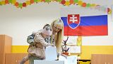Uma menina coloca o voto da mãe na urna de uma assembleia de voto em Bratislava