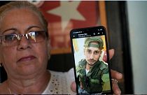 یک مادر کوبایی و تصویر فرزندش که برای جنگ در اوکراین به استخدام ارتش روسیه درآمده است