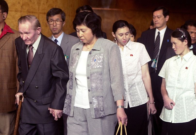 Charles Jenkins feleségével, Szoga Hitomival, mögöttük két lányuk fehérben, Mika és Belinda, 2004-ben