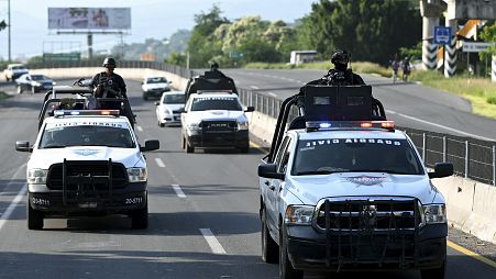 Members of the Civil Guard escort a truck carrying lemons (out of frame) in the Apatzingan-Nueva Italia highway section, Michoacan State, Mexico, on September 20, 2023. 