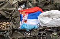 A Serbian flag is displayed along weapons and military equipment seized during the Kosovo police operation in the village of Banjska displayed in police camp in Kosovo 25/9/23