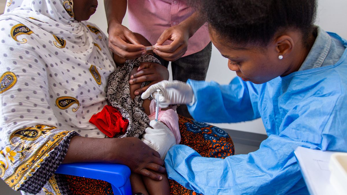 A child receives a vaccine against malaria.