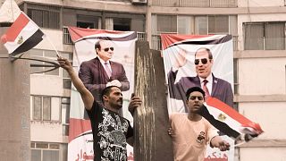 Mısır Cumhurbaşkanı Abdulfettah Sisi'nin posterlerinin önünde Mısır bayrağı sallayan destekçileri 
