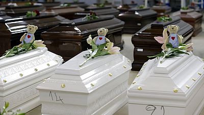 Teddybären und Blumen auf den Särge verstorbener Migranten in einem Hangar am Flughafen von Lampedusa (5. Oktober 2013)