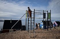 Children play in a playground in the remote Eastern Greenland village of Ittoqqortoormiit in Scoresby Sound Fjord, Eastern Greenland on August 17, 2023.