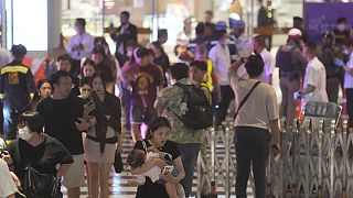 Посетители покидают торговый центр Siam Paragon  в Бангкоке после того, как там открыл стрельбу подросток. 
