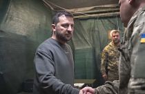 Wolodymyr Selenskyj wird von einem Soldaten begrüßt