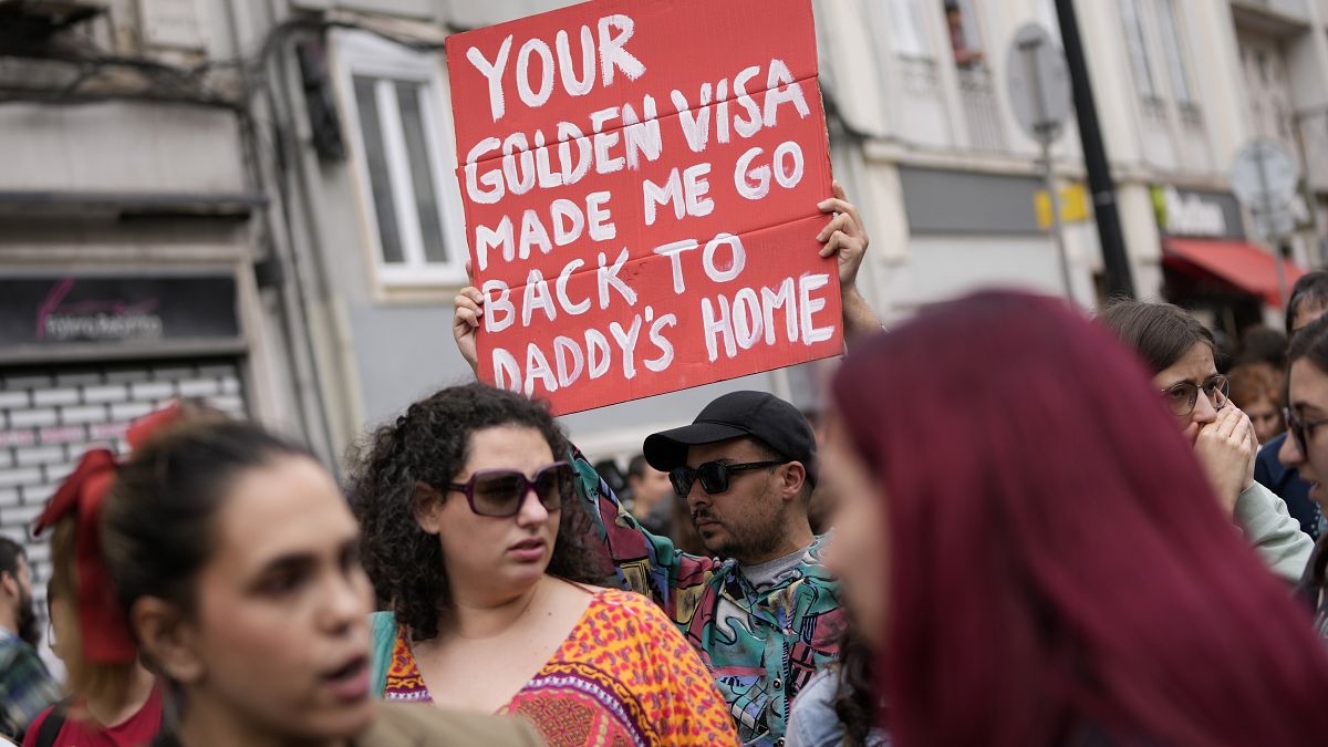 A protestor carries a poster during a demonstration to demand solutions for Portugal's housing crisis, in Lisbon, on April.