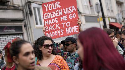 A protestor carries a poster during a demonstration to demand solutions for Portugal's housing crisis, in Lisbon, on April.
