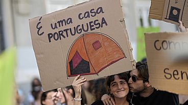 Палатка на плакате – это и есть "дом для португальцев", по мнению участников акции за расширение доступа молодёжи к покупке собственности.