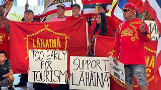  Жителите на Лахайна държат знаци в Капитолия на щата Хавай в Хонолулу на 3 октомври 2023 година 
