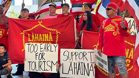 Lahaina residents hold signs at the Hawaii State Capitol in Honolulu on 3 October 2023.