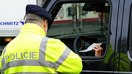 Un policía checo controla a un vehículo en la frontera con Eslovaquia
