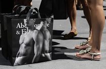 young women pause with their Abercrombie & Fitch shopping bags on the sidewalk along Fifth Avenue in New York. July 10, 2012