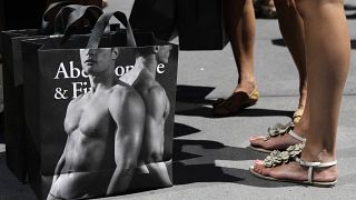 young women pause with their Abercrombie & Fitch shopping bags on the sidewalk along Fifth Avenue in New York. July 10, 2012