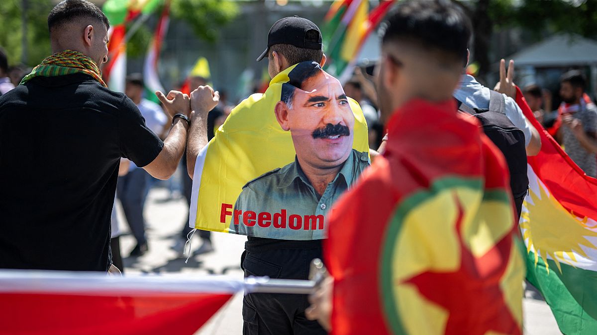 متظاهر كردي يرتدي علما بصورة عبد الله أوغلان