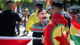 متظاهر كردي يرتدي علما بصورة عبد الله أوغلان