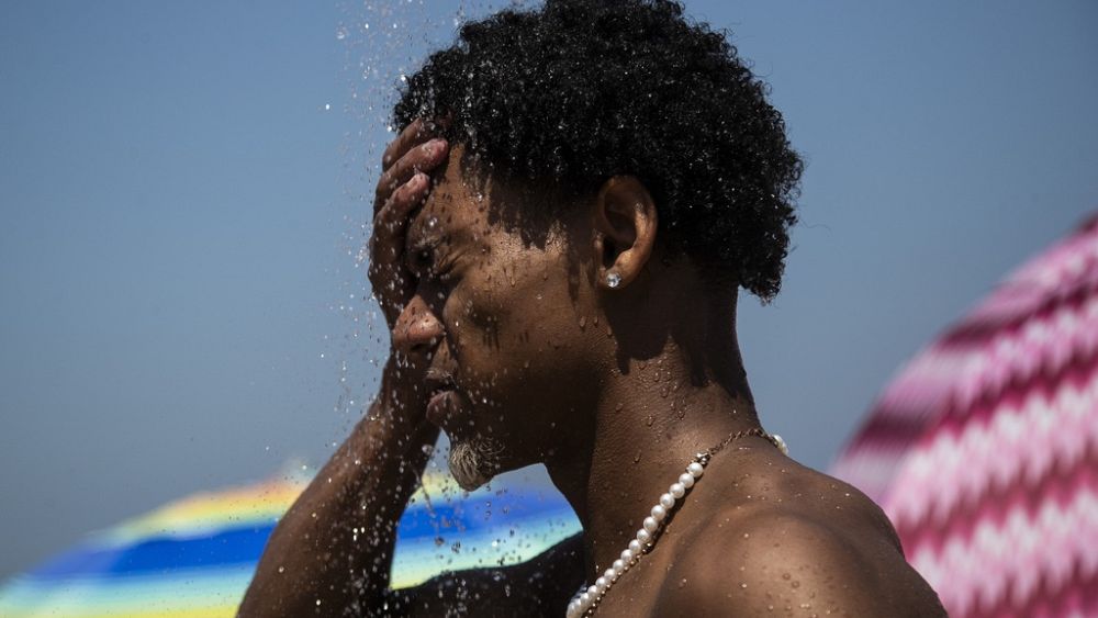 Мъж се охлажда под душа на плажа Ипанема, Рио де