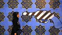 FILE - Иранская женщина проходит мимо антиамериканской фрески, нарисованной на стене бывшего посольства США, в Тегеране, Иран, суббота, 2 ноября 2013 г.